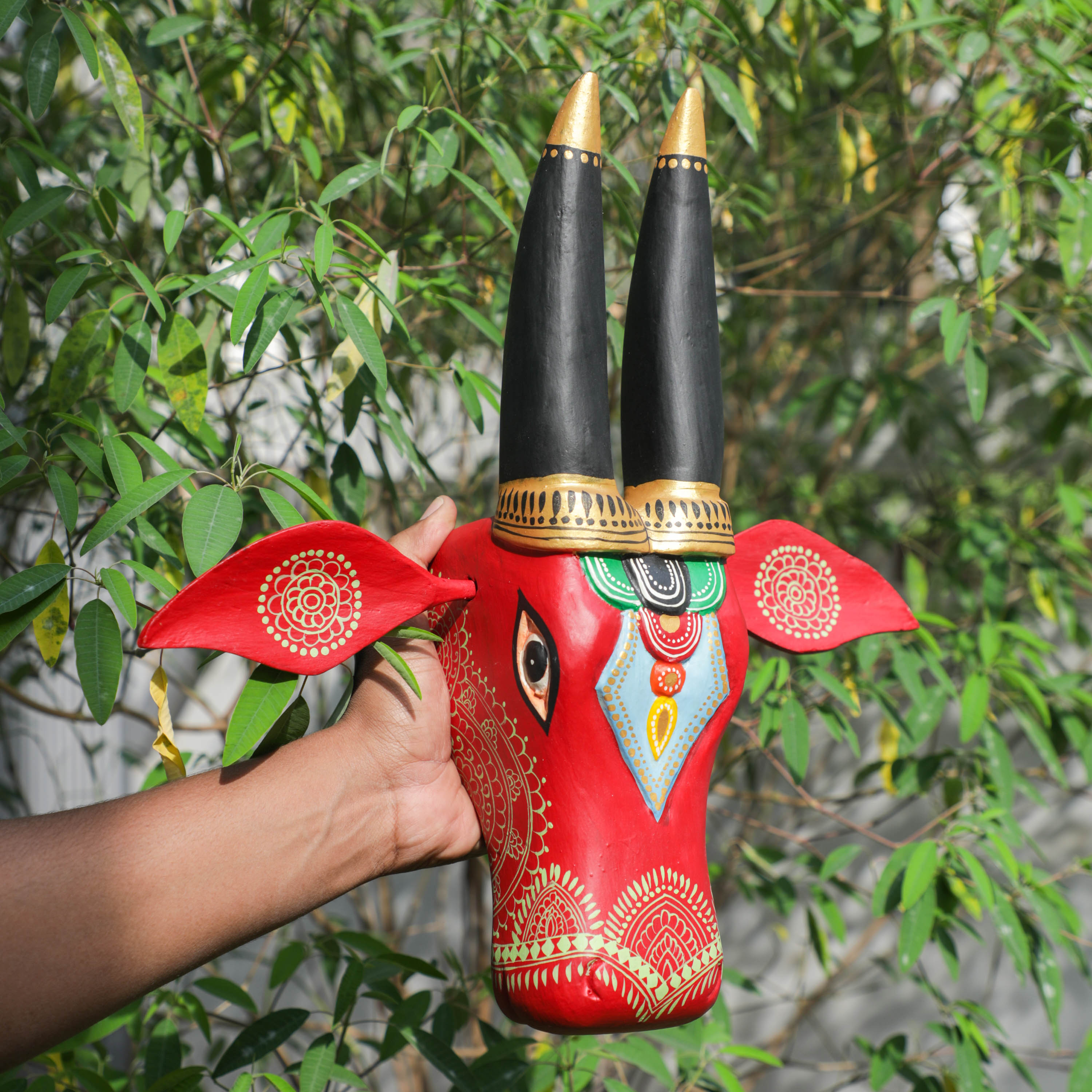 holding the wooden bull head in hand